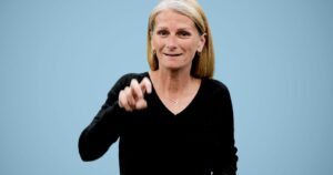 A white woman with long blonde hair and a black top, Tammy Burns, Clerc Center Project Manager, signs into camera about IEP Toolkits and resources for families of deaf and hard of hearing children.