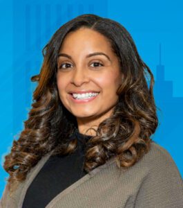 A light skinned Hispanic woman with brown eyes and brown mid-length hair.