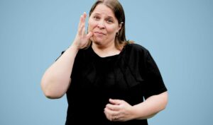 A white woman wearing a black top, Catherine Valcourt-Pearce, Clerc Center editor signs into the camera about Parent Advocacy for deaf and hard of hearing children.