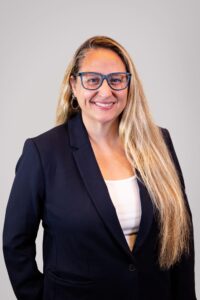 Stacy Abrams, a white woman with glasses and blonde hair wearing a navy blazer over a white shirt poses for her staff photo. Abrams serves as a Project Manager, Early Intervention